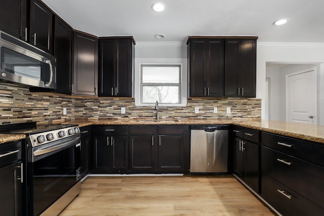 kitchen with decorative backsplash, light stone countertops, sink, and appliances with stainless steel finishes