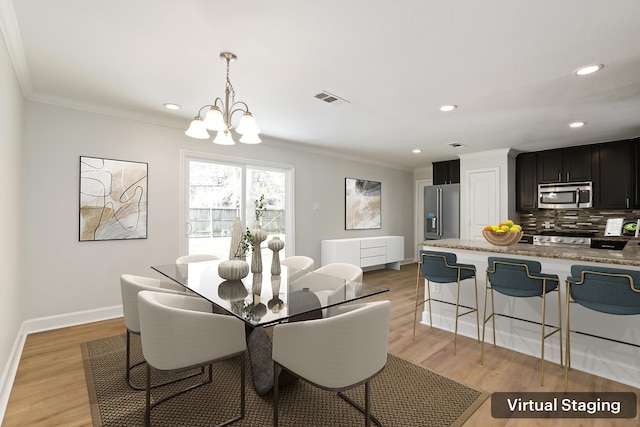 dining space with crown molding, light hardwood / wood-style flooring, and an inviting chandelier