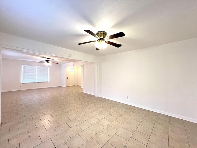 tiled spare room featuring ceiling fan