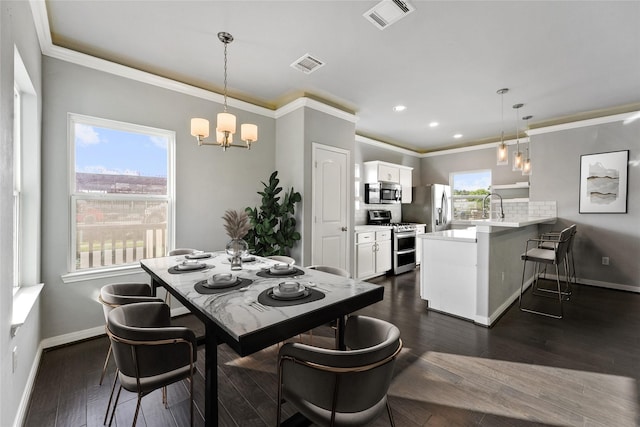 dining room with dark wood-type flooring, crown molding, a wealth of natural light, and an inviting chandelier