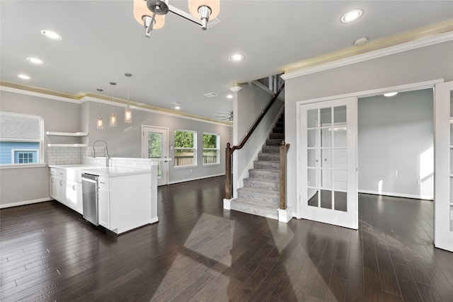 kitchen featuring white cabinetry, dishwasher, tasteful backsplash, crown molding, and decorative light fixtures