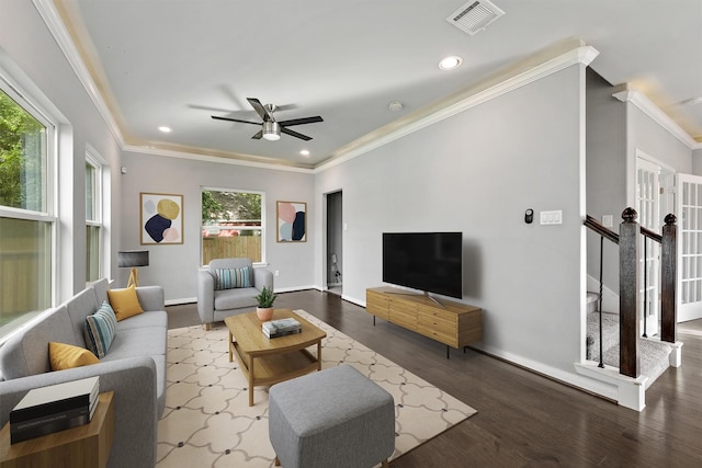 living room with plenty of natural light, ceiling fan, ornamental molding, and dark wood-type flooring