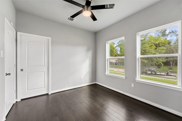 empty room with dark hardwood / wood-style floors and ceiling fan