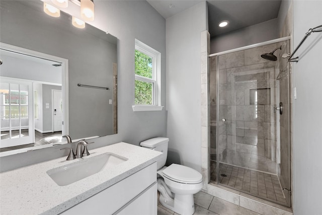 bathroom featuring an enclosed shower, vanity, toilet, and tile patterned floors