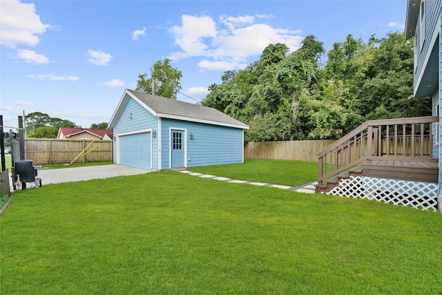 view of yard with a wooden deck, an outbuilding, and a garage