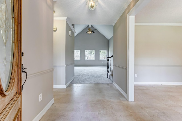 foyer entrance featuring lofted ceiling, ceiling fan, ornamental molding, a textured ceiling, and light colored carpet