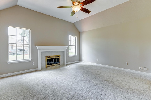 unfurnished living room featuring a tile fireplace, vaulted ceiling, and a wealth of natural light