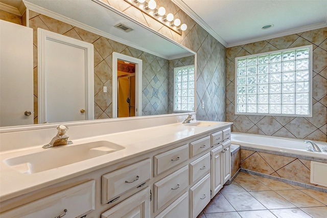 bathroom featuring tile patterned floors, tiled tub, vanity, and ornamental molding