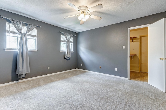 carpeted empty room featuring a textured ceiling and ceiling fan