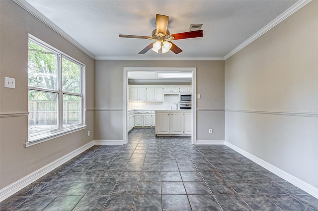 unfurnished living room with ceiling fan, sink, and crown molding