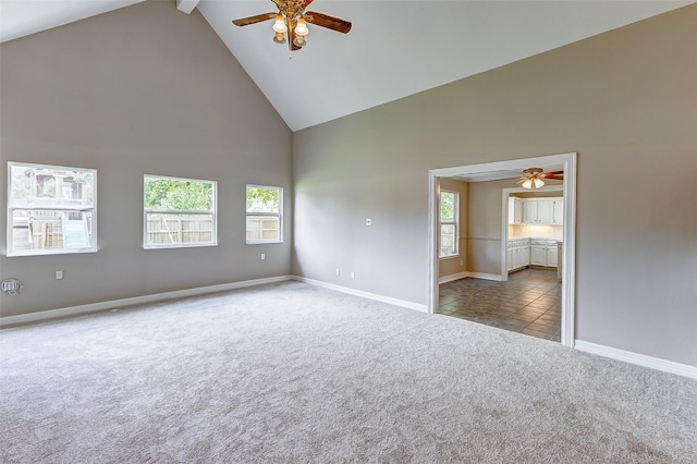 carpeted spare room featuring a wealth of natural light, beam ceiling, and high vaulted ceiling