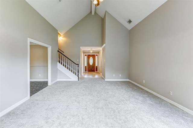 unfurnished living room featuring carpet flooring, beam ceiling, high vaulted ceiling, and ceiling fan