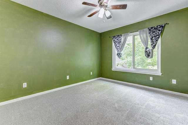 carpeted spare room featuring ceiling fan and a textured ceiling