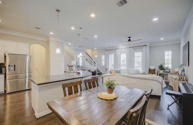 dining space with dark hardwood / wood-style flooring, ceiling fan, crown molding, and sink