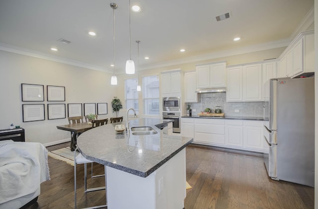 kitchen featuring appliances with stainless steel finishes, a center island with sink, hanging light fixtures, and sink