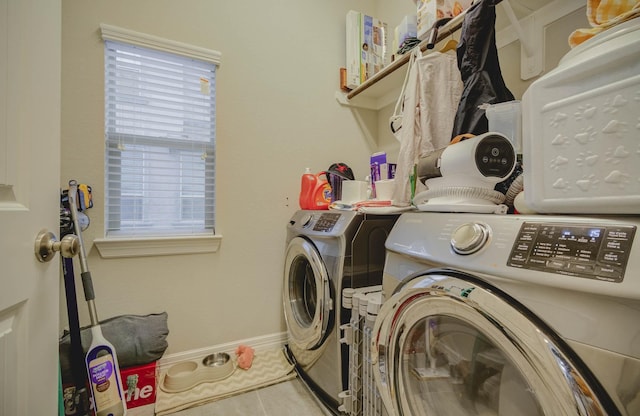 clothes washing area featuring tile patterned floors, plenty of natural light, and washing machine and dryer