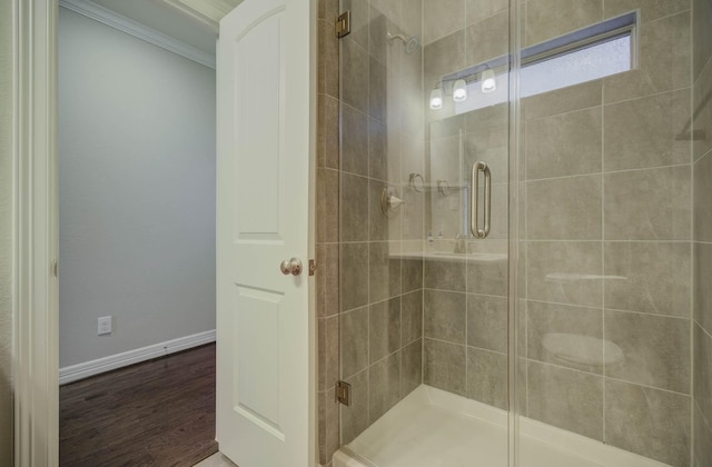 bathroom featuring hardwood / wood-style flooring, a shower with door, and crown molding