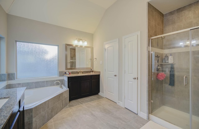 bathroom featuring tile patterned flooring, shower with separate bathtub, vanity, and vaulted ceiling