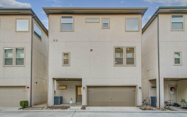 view of front of house with a garage and central AC unit