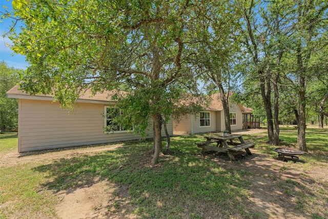 rear view of house featuring a yard and an outdoor fire pit