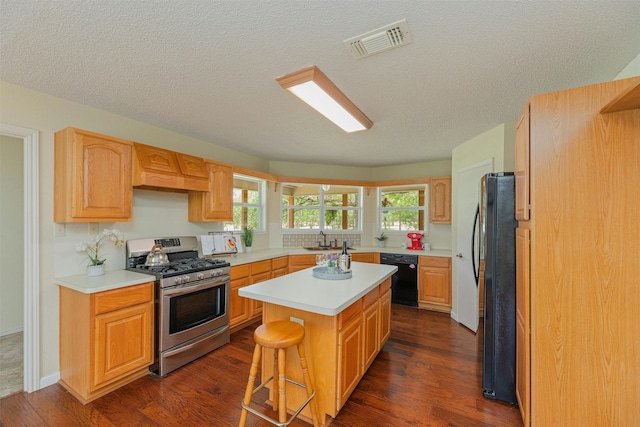 kitchen featuring a center island, sink, dark wood-type flooring, a breakfast bar area, and black appliances