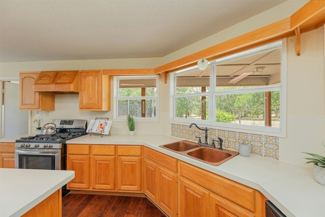 kitchen with premium range hood, dark wood-type flooring, sink, a textured ceiling, and stainless steel range with gas stovetop