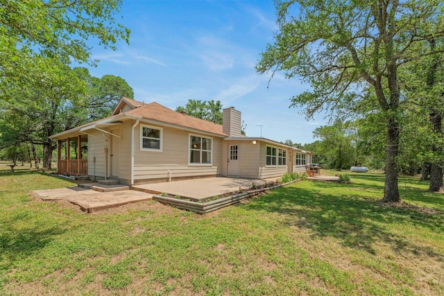 rear view of house with a lawn and a patio