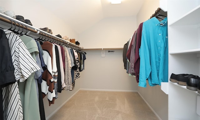 spacious closet featuring lofted ceiling and light carpet