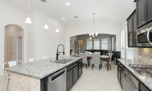 kitchen featuring sink, stainless steel appliances, an island with sink, and pendant lighting