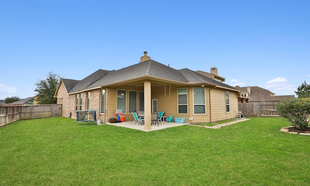 rear view of house with a yard and a patio