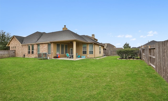 rear view of house with a patio and a lawn