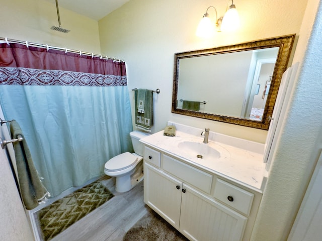 bathroom with hardwood / wood-style flooring, vanity, toilet, and walk in shower