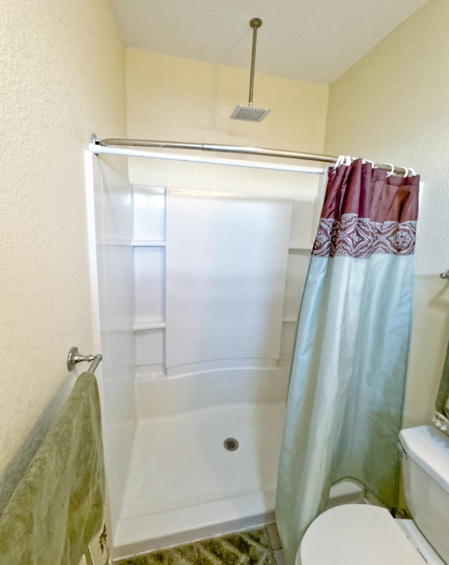 bathroom featuring toilet and a shower with shower curtain