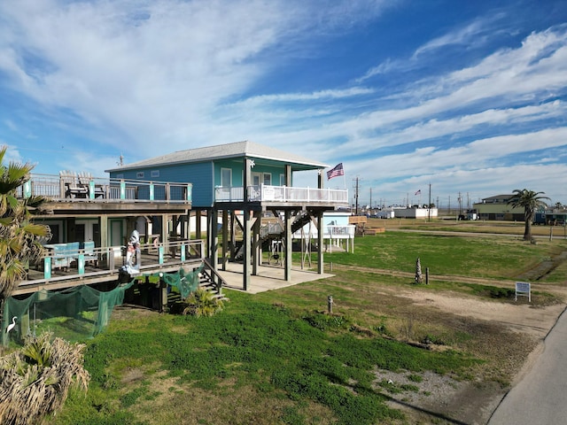 rear view of house with a yard, a balcony, and a patio area