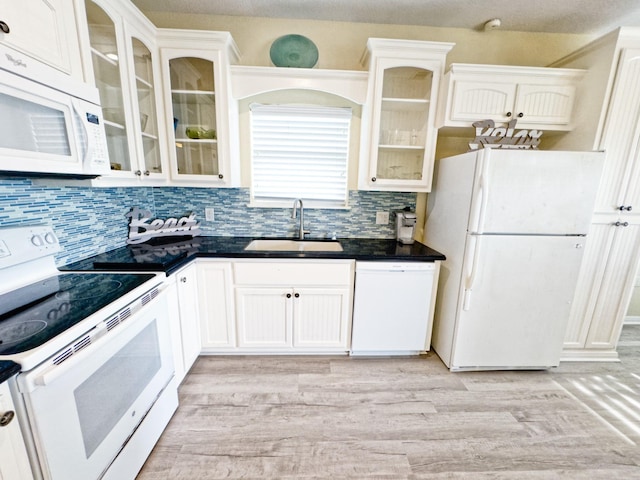 kitchen with sink, white cabinets, and white appliances