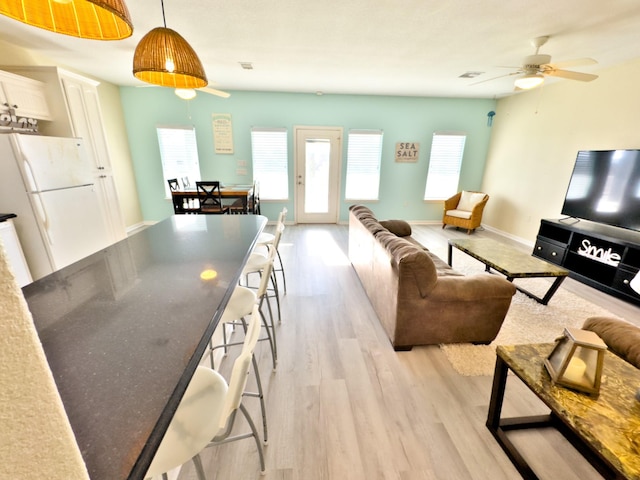 living room with ceiling fan and light hardwood / wood-style floors