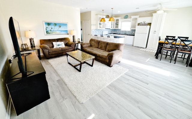 living room with ceiling fan and light hardwood / wood-style floors