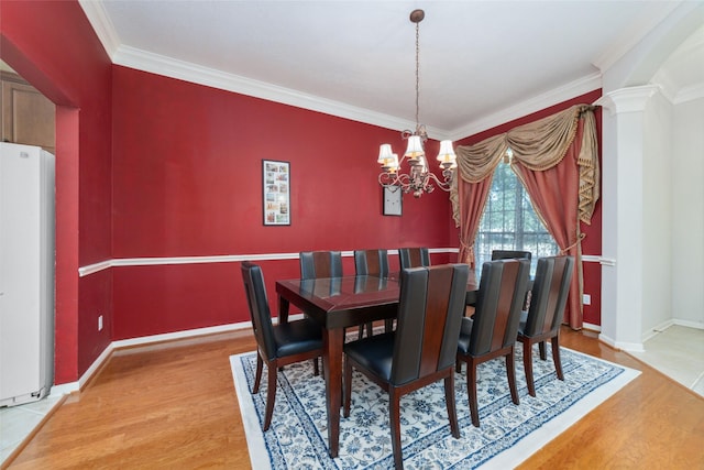 dining room with ornamental molding, an inviting chandelier, and wood-type flooring