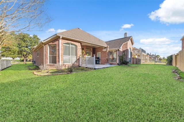 rear view of property with a yard and a patio area