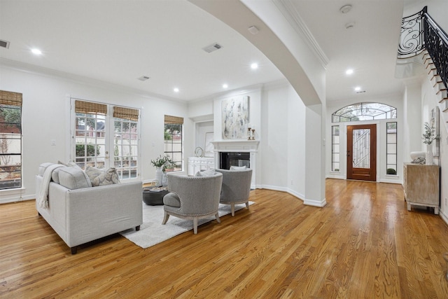 living room featuring light hardwood / wood-style floors and crown molding