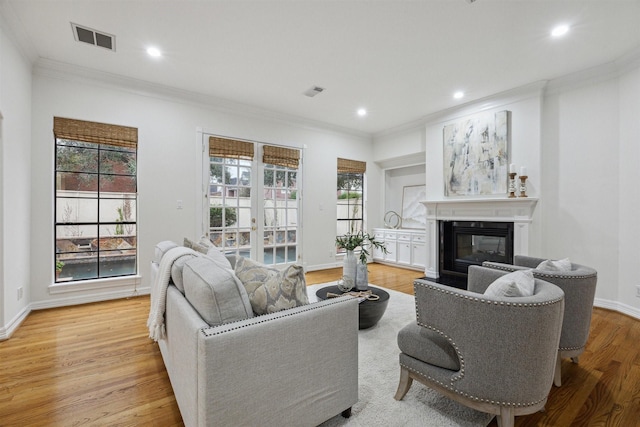 living room with light hardwood / wood-style flooring and ornamental molding