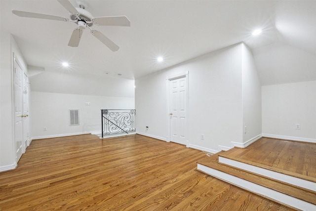 additional living space with ceiling fan, wood-type flooring, and vaulted ceiling