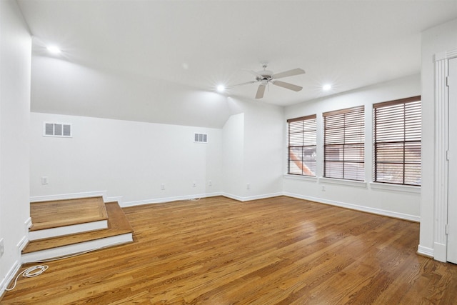 empty room with ceiling fan, wood-type flooring, and vaulted ceiling