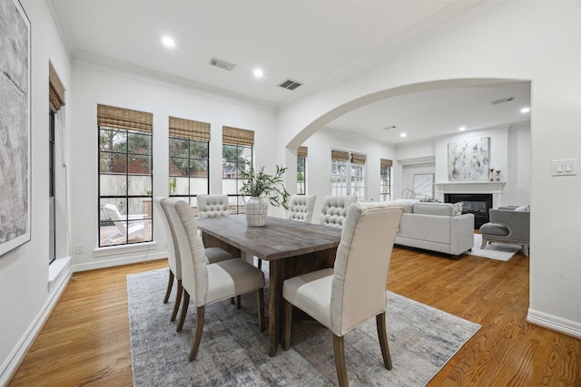 dining area with crown molding and light hardwood / wood-style floors