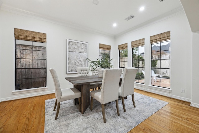 dining area with light hardwood / wood-style floors and crown molding