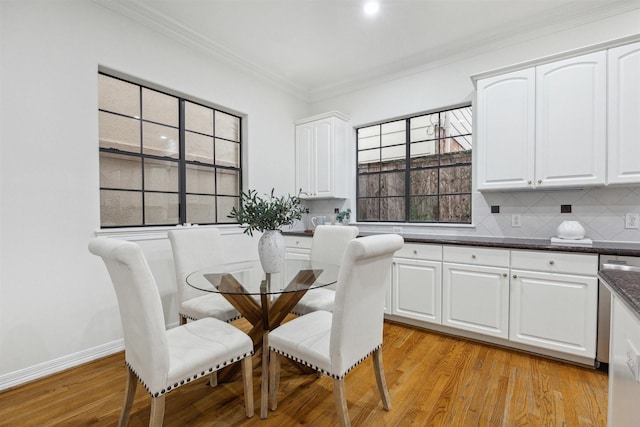 dining space with light hardwood / wood-style flooring and ornamental molding