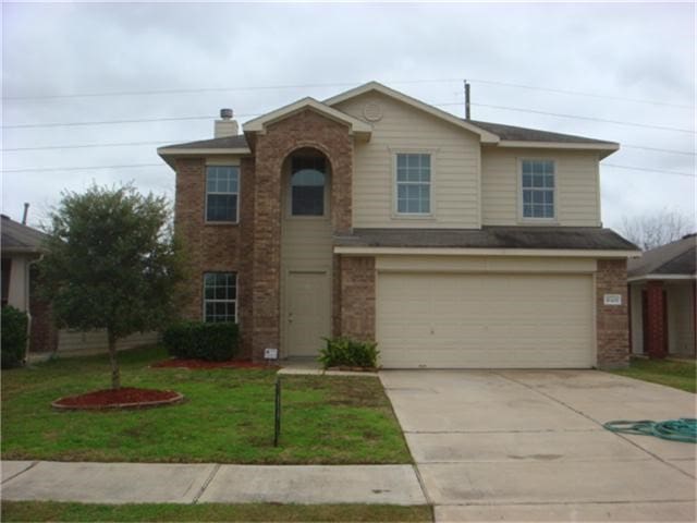 view of front of property with a garage and a front lawn