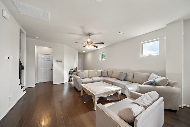 living room featuring ceiling fan and dark hardwood / wood-style floors