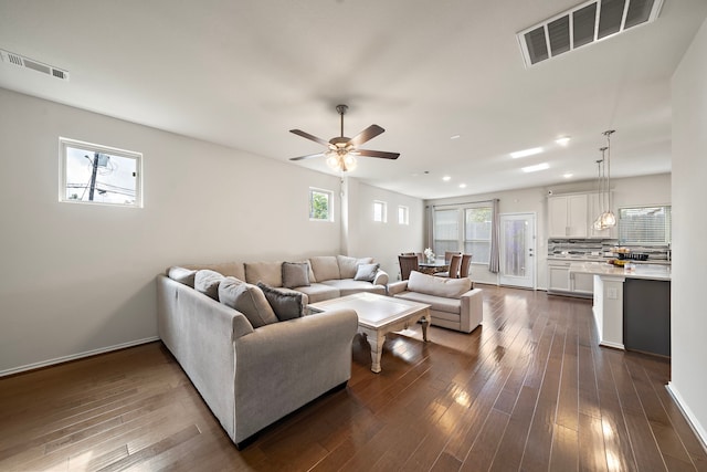 living room with ceiling fan and dark hardwood / wood-style flooring