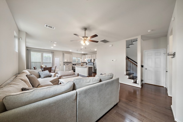 living room with dark hardwood / wood-style floors and ceiling fan